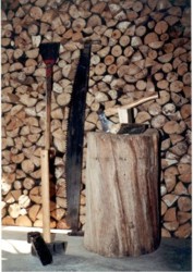 Waldarbeitsgeräte: Schrotsäge, Schäleisen, Vorschlaghammer,  Axt und Spaltkeil. Im Hintergrund Wintervorrat Foto: Hejo Mies